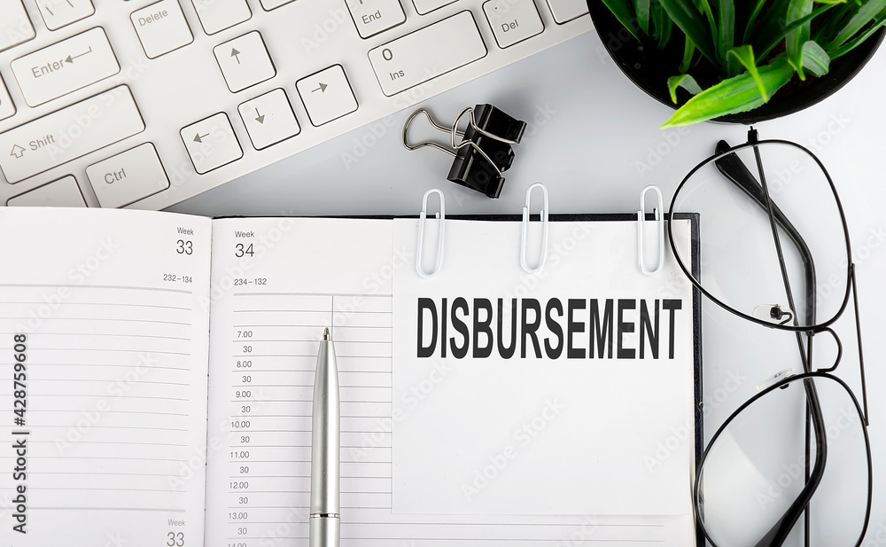 Poster text disbursement on white stickers on the notebook with keyboard and glasses.