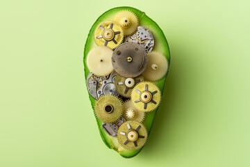 Creative idea layout fresh half avocado with clock mechanism inside on pastel green background....