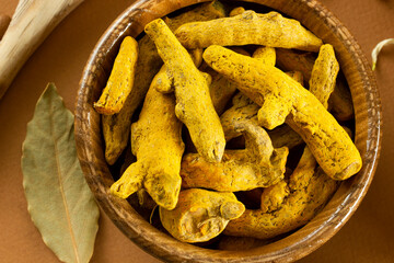 Turmeric roots in a wooden bowl. Bay Leaf.