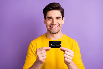 Photo of handsome cheerful man hands hold banking card smile isolated on pastel violet color background