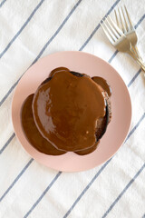 Homemade Chocolate Pancakes on a pink plate, top view. Flat lay, overhead, from above.