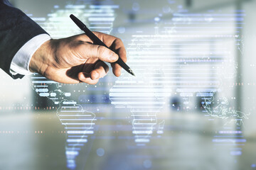Multi exposure of businessman hand with pen working with abstract graphic world map on blurred office background, big data and networking concept