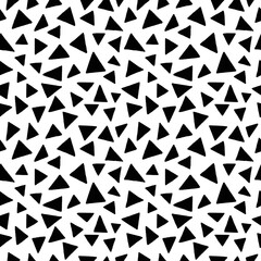Seamless pattern. Black triangles in chaotic order on a white background.	
