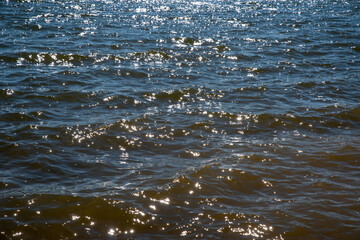 Gorgeous angle on calm water surface waves glistening in the sun.