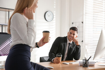 Man flirting with his colleague during coffee break in office