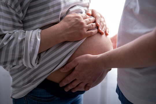 close up hands on mother and father making heart on pregnant big belly advanced pregnancy. Lover Parents waiting baby family pregnancy