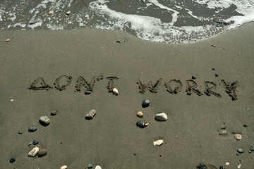 Words Don't Worry on beach sand