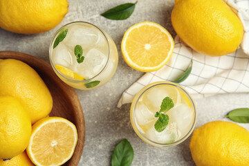 Fototapeta na wymiar Cool freshly made lemonade and fruits on grey table, flat lay