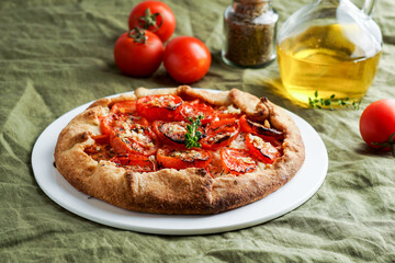 Galette with fresh tomatoes, herbs and cheese, open pie