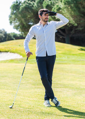 A young Caucasian male playing golf on a professional golf course