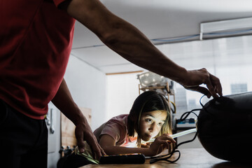 Father and daughter working at diving workshop center - Diver tank visual inspection - Focus on...