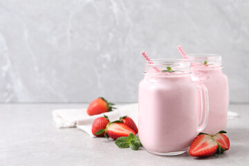 Delicious drink with strawberries on light table, space for text