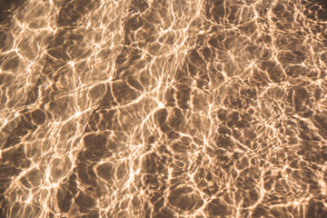 The waves of the sea when hitting the morning light create light trails on the beach.