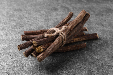 Dried sticks of liquorice root on grey table, closeup
