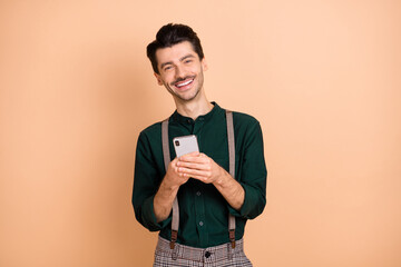 Photo of young handsome man happy positive smile use cellphone chat type social post repost...