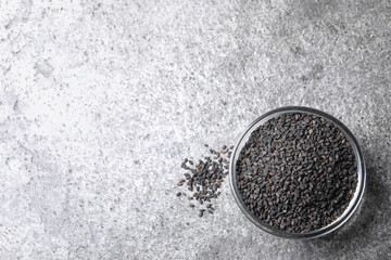 Black sesame seeds on grey table, flat lay. Space for text