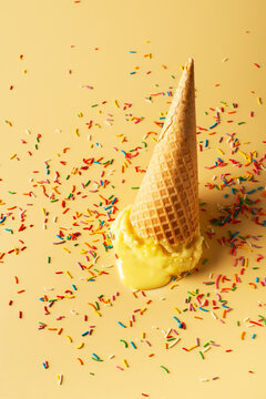 Melted Yellow Ice Cream Cone With Confetti Creative Pastel Background