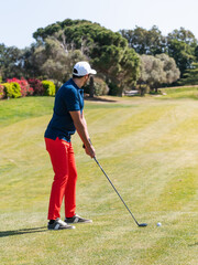 Obraz premium A young Caucasian male playing golf on a professional golf course