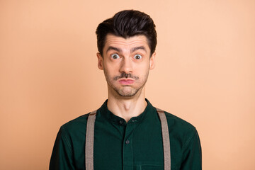 Photo of young funky funny humorous man hold breath air fooling around childish isolated on beige color background