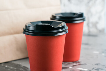 Two paper cups and a craft takeaway bag on a gray background copy space. Concept for the development of the restaurant business and food delivery during quarantine covid 19