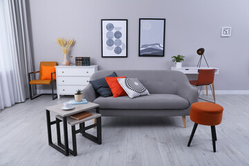 Stylish grey living room interior with comfortable sofa