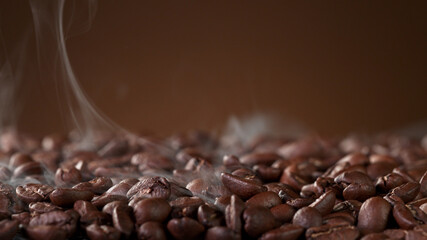 Pile of fresh roasted coffee beans with smoke around