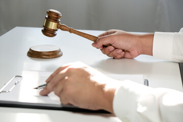 Legal counsel presents to the client a signed contract with gavel and legal law. justice and lawyer concept.