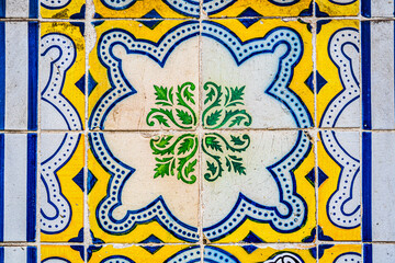 Traditional vintage blue yellow and green ceramic glazed tiles (azulejo) on the walls of Lisbon, Portugal