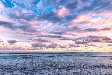 Beautiful pink sunset sky with clouds on the beach in Matapalo, Costa Rica. Central America. Sky background on sunset. Tropical sea.