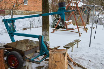 woodcutter in the yard,mechanical wood splitter in the winter in the snow in the yard
