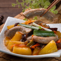 Eating pan-fried pork small intestine with pineapple.