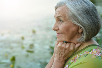 portrait of a happy smiling senior woman by lake