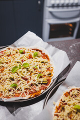 homemade vegan pizzas getting prepared on kitchen benchtop, healthy plant-based food