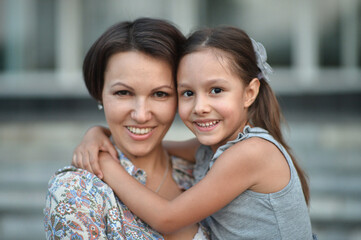 Portrait of happy mother and daughter posing outdoors