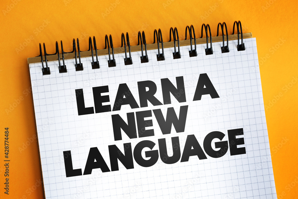 Aufkleber learn a new language text quote on notepad, concept background.