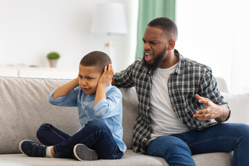 Aggressive Black Father Shouting At Unhappy Kid Boy At Home