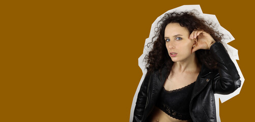 Young attractive woman in leather motorcycle jacket and top eavesdropping, magazine fashion style