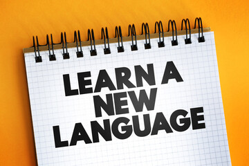 Learn A New Language text quote on notepad, concept background.