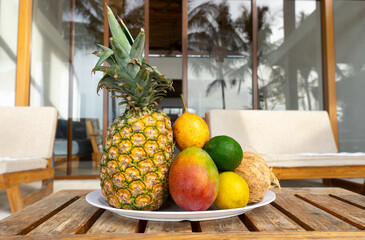A plate of tropical fruits on a wooden table