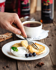 Russian breakfast cottage cheese pancakes with sour cream and coffee