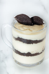 Delicious magnolia, oreo, piece of chocolate in glass coffee on white