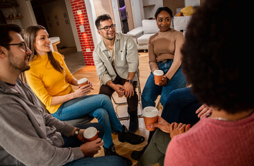 Diverse group of people sitting in circle in group therapy session.