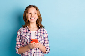 Photo of nice optimistic red hairdo girl write telephone look empty space wear plaid shirt isolated on blue color background