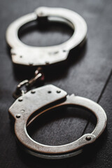 Handcuffs on brown background studio shoot dark