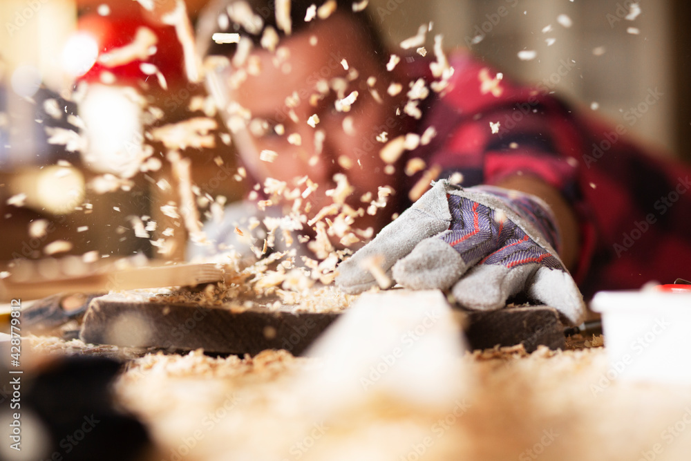 Wall mural Close up of carpenter working on wooden table in carpentry shop.