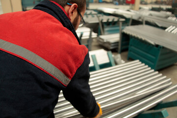 New steel pipes. A worker at the factory.