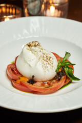 burrata cheese with tomatoes on a white plate