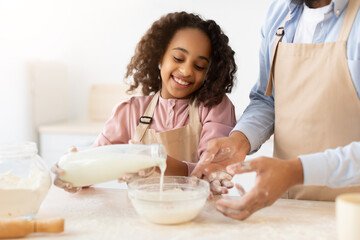 Obraz na płótnie Canvas Happy black family preparing dough together in kitchen