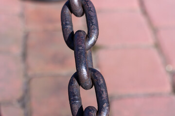 Heavy cast iron chain with rust. Protective fence on the bank of the Neva River in St. Petersburg.