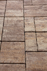 Paving the street with cement blocks of various shapes with a design that repeats the natural color. Selective focus on the center of the composition.